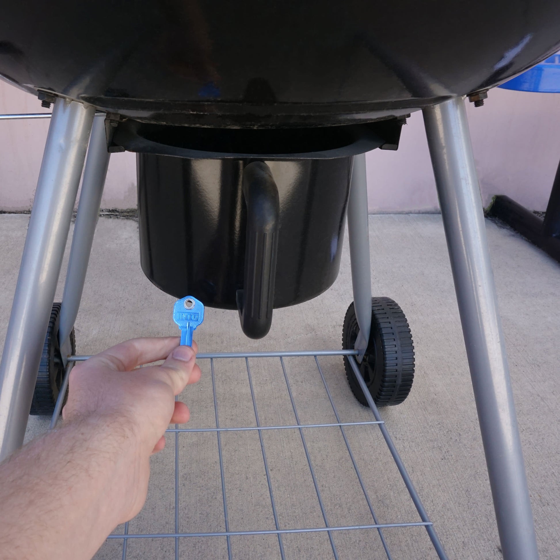 Load image into Gallery viewer, 50663 Magnetic Key, KW1-66 Blue - Hand Holding Blue Magnetic Key Beneath a Barbeque Grill