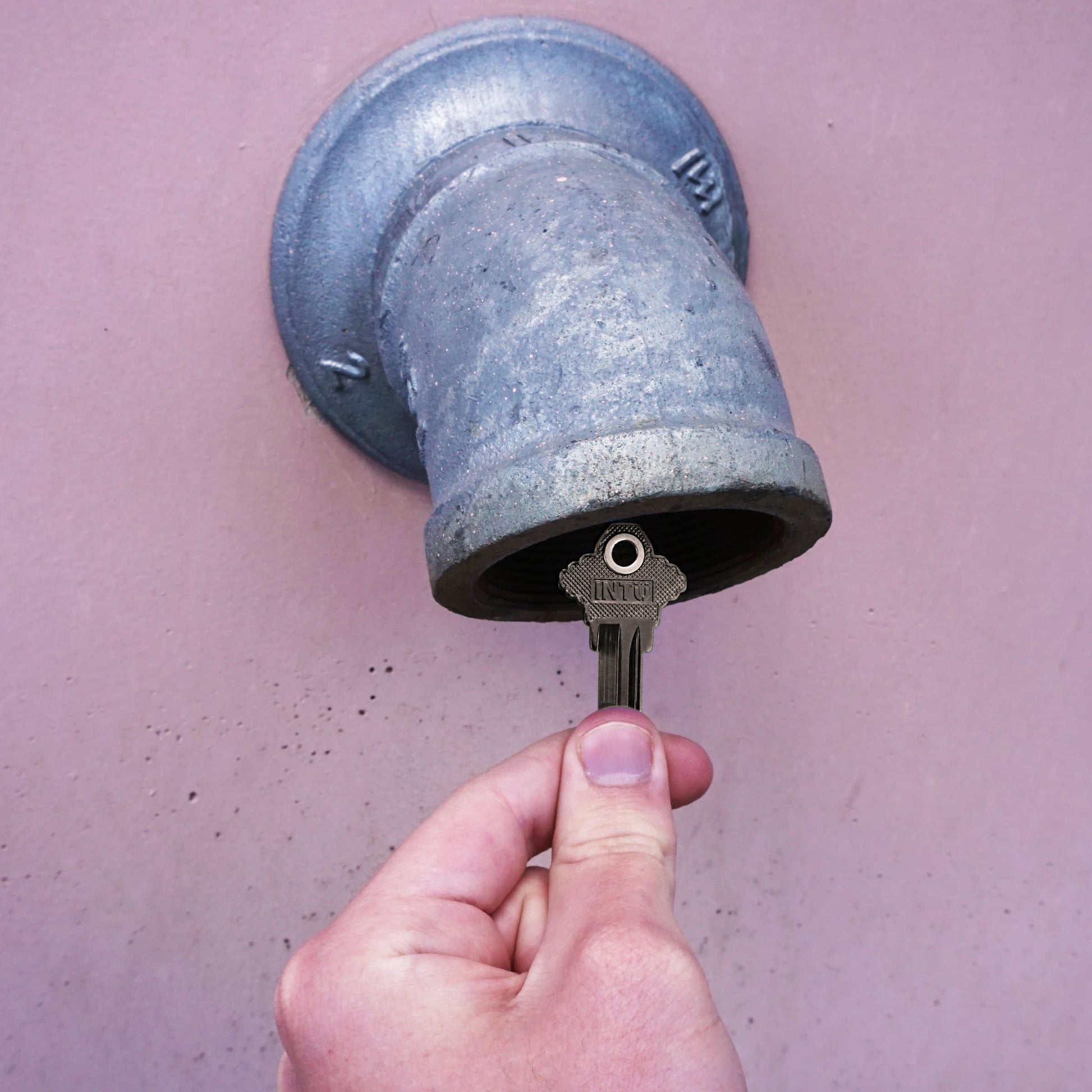 Load image into Gallery viewer, 50686 Magnetic Key, SC1-68 Black - Hand Holding Magnetic Key Next to a Drain Pipe