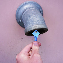 Load image into Gallery viewer, 50683 Magnetic Key, SC1-68 Blue - Hand Holding Blue Magnetic Key Next to a Metal Drain Pipe